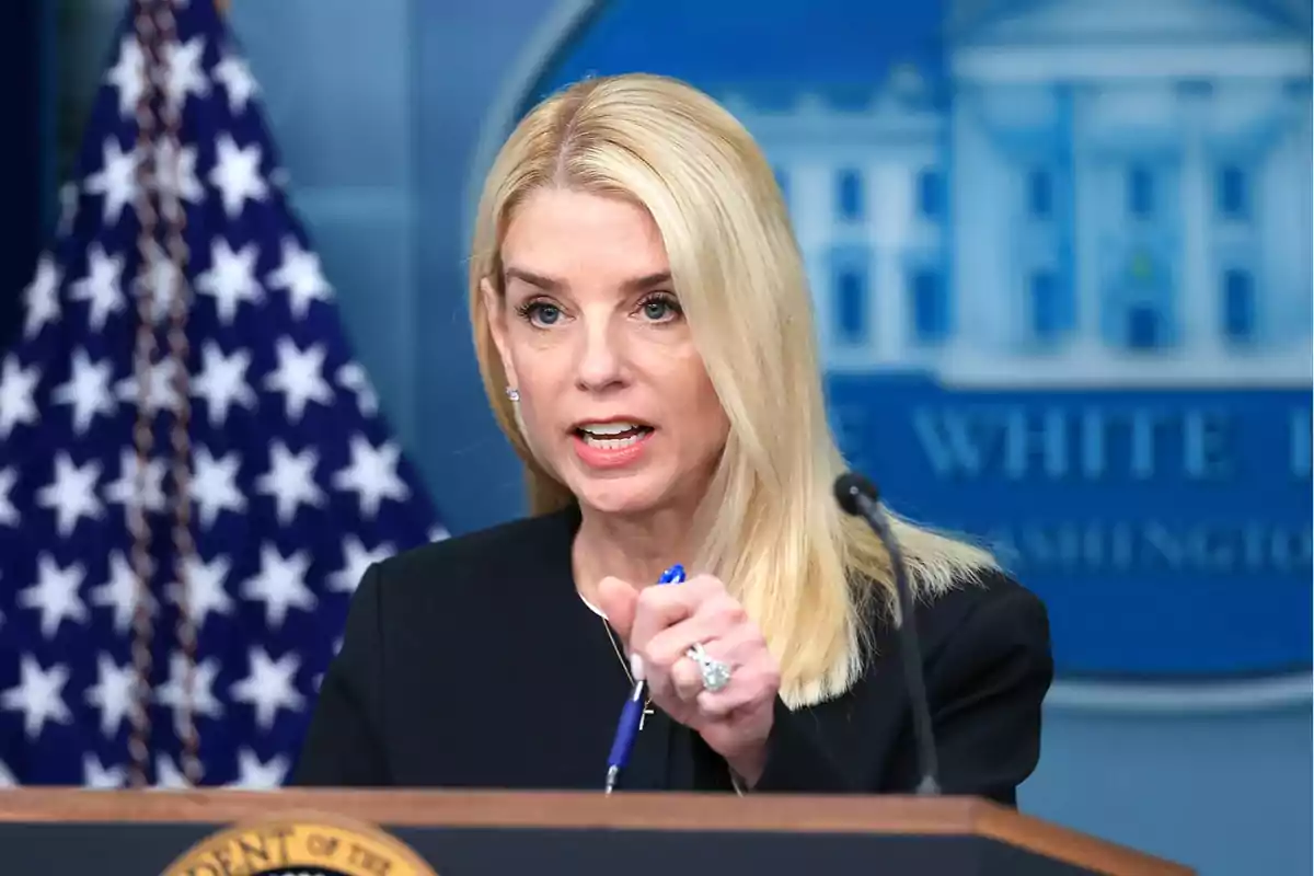 Mujer rubia hablando en una conferencia de prensa con una bandera de Estados Unidos y un podio presidencial al fondo Mujer rubia hablando en una conferencia de prensa con una bandera de Estados Unidos y un podio presidencial al fondo