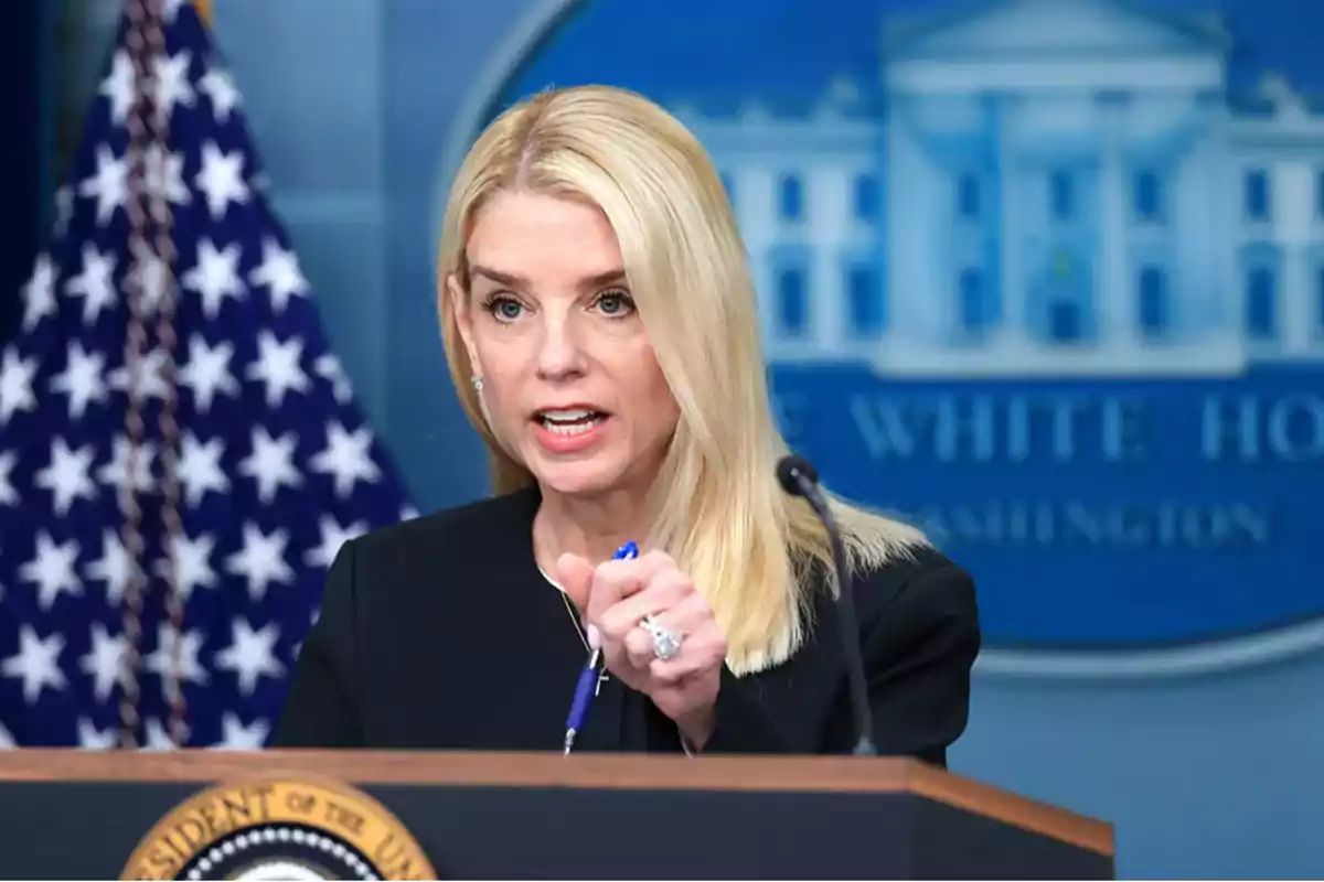 Mujer rubia hablando en una conferencia de prensa en la Casa Blanca con una bandera de Estados Unidos al fondo Mujer rubia hablando en una conferencia de prensa en la Casa Blanca con una bandera de Estados Unidos al fondo