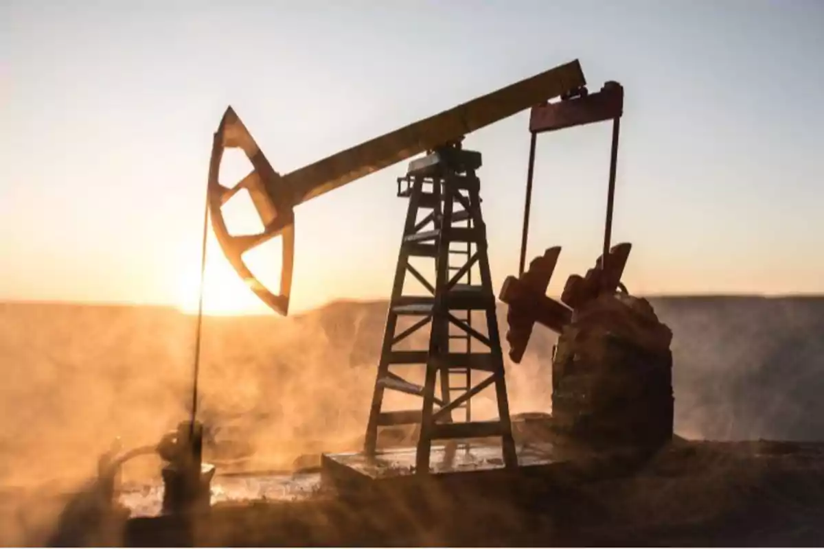 Bomba extractora de petróleo trabajando al atardecer en un campo con neblina Bomba extractora de petróleo trabajando al atardecer en un campo con neblina