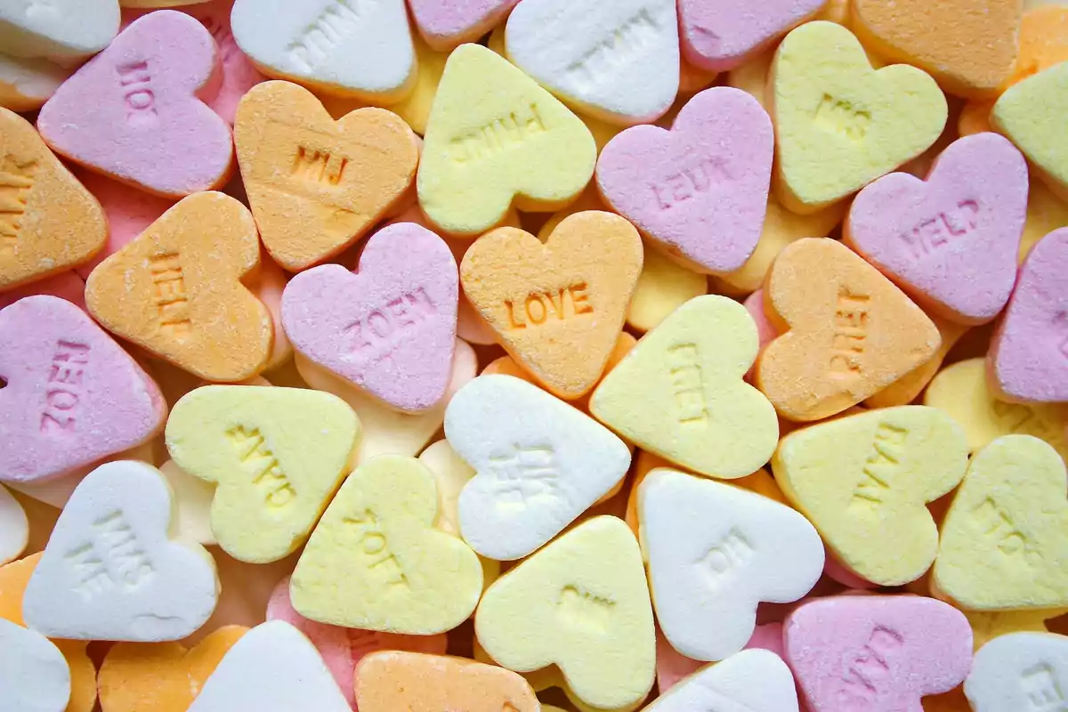 Pastel-colored heart-shaped candies with words engraved on the surface Pastel-colored heart-shaped candies with words engraved on the surface
