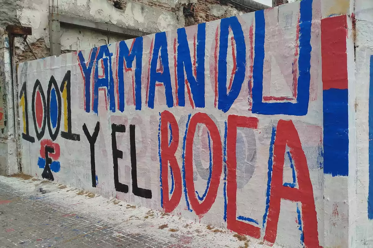Mural pintado en una pared con las palabras 1001 Yamandú y el Boca en letras grandes de colores azul, rojo, negro y amarillo