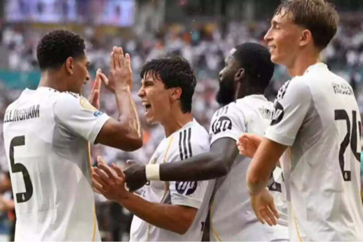 Jugadores de fútbol celebran un gol con entusiasmo durante un partido Jugadores de fútbol celebran un gol con entusiasmo durante un partido