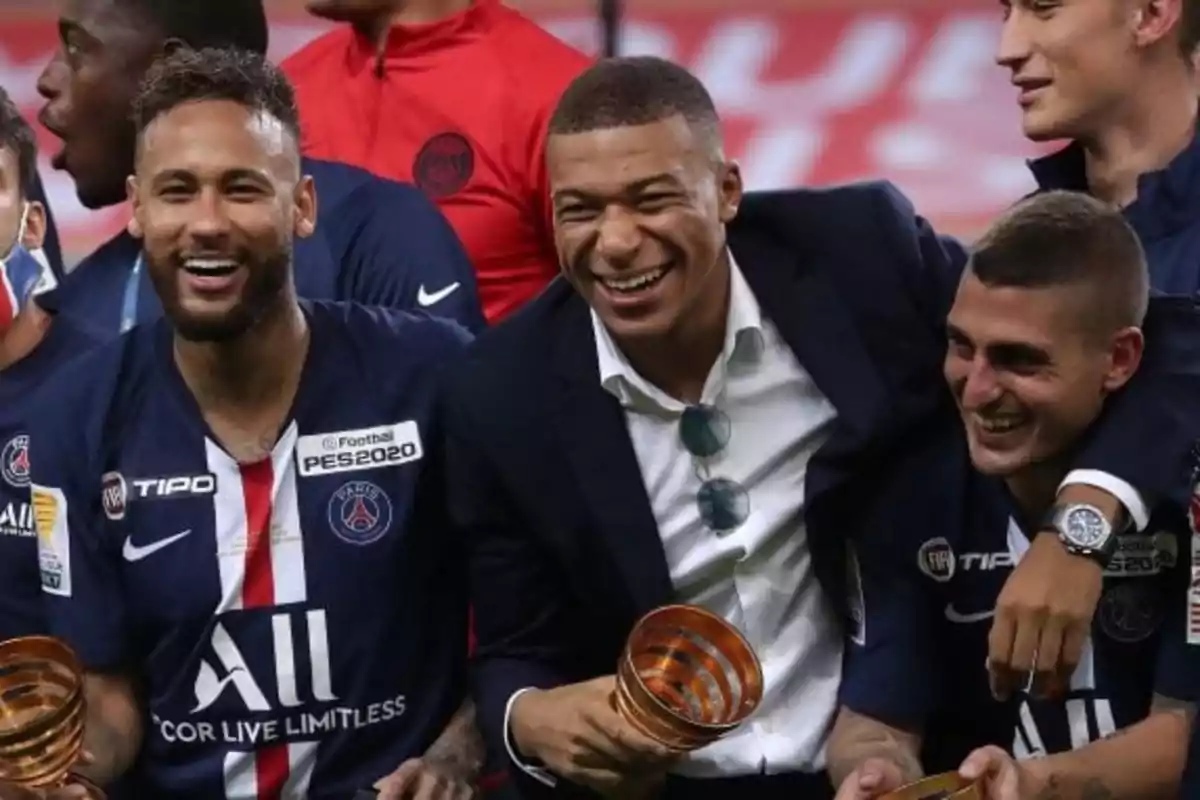 Jugadores del PSG sonríen y celebran juntos sosteniendo trofeos en un estadio Jugadores del PSG sonríen y celebran juntos sosteniendo trofeos en un estadio