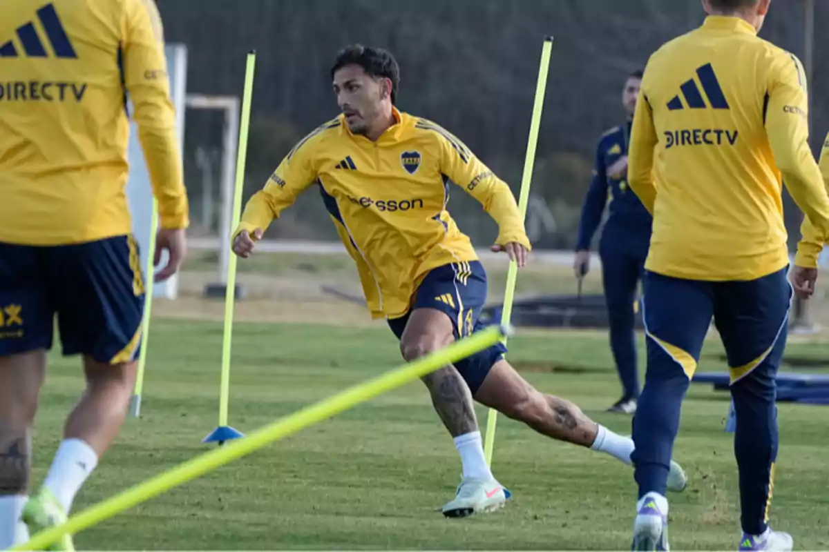 Soccer players training on a field with cones and stakes, wearing yellow and blue sportswear Soccer players training on a field with cones and stakes, wearing yellow and blue sportswear