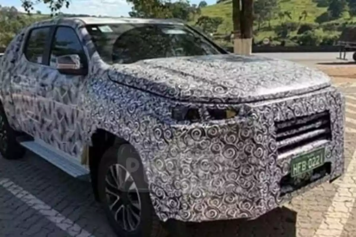 Pickup truck covered with test camouflage parked in an outdoor location Pickup truck covered with test camouflage parked in an outdoor location