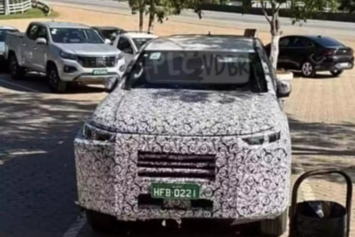 Pickup truck covered with test camouflage parked on the street next to other vehicles Pickup truck covered with test camouflage parked on the street next to other vehicles