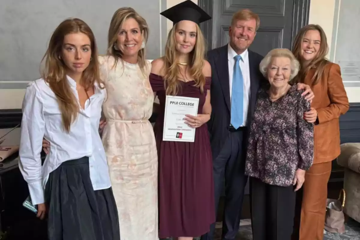 Group of six people posing together at a graduation celebration, one of them wearing a cap and holding a diploma while everyone smiles at the camera. Group of six people posing together at a graduation celebration, one of them wearing a cap and holding a diploma while everyone smiles at the camera.
