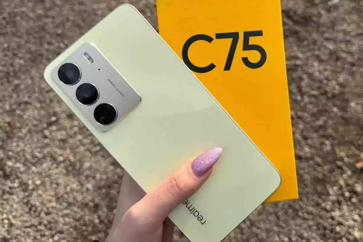 Person holding a light yellow Realme phone next to a yellow box with the text C75 Person holding a light yellow Realme phone next to a yellow box with the text C75