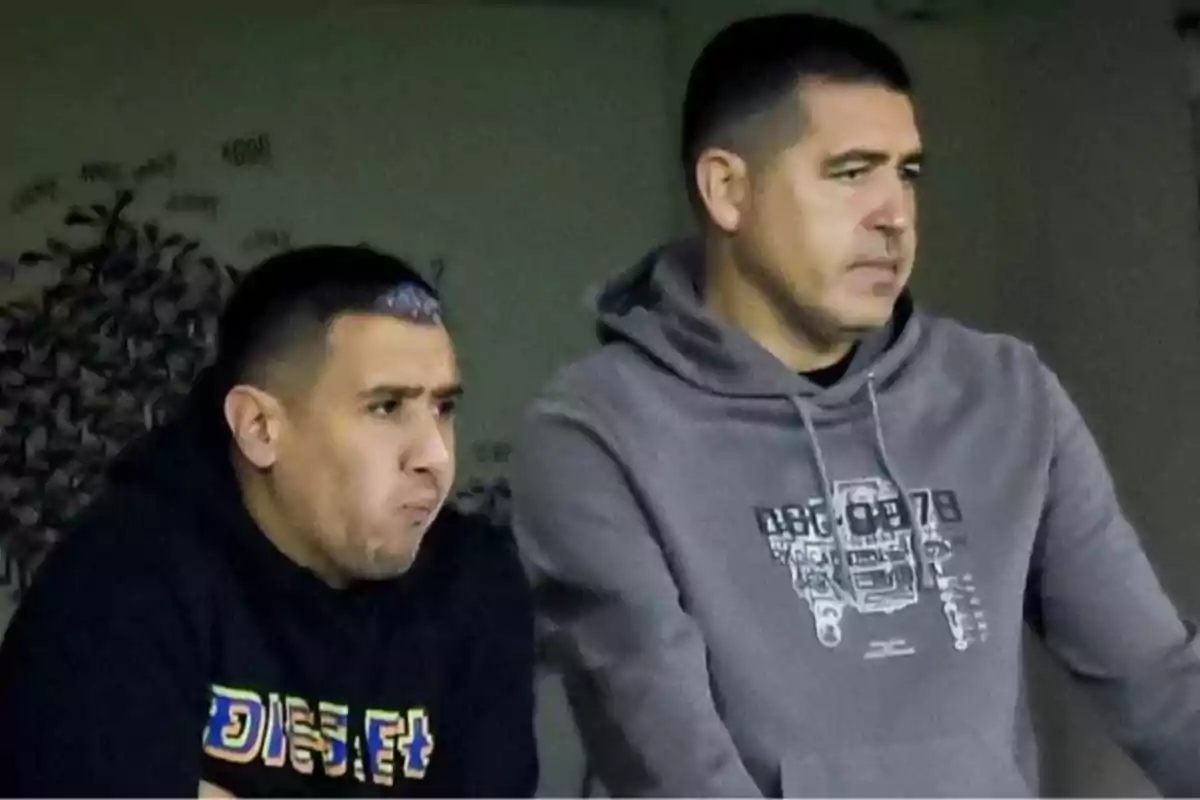 Dos hombres con expresión seria observan algo fuera de la imagen uno lleva una sudadera negra y el otro una sudadera gris Dos hombres con expresión seria observan algo fuera de la imagen uno lleva una sudadera negra y el otro una sudadera gris