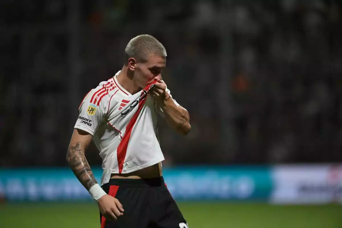 Soccer player kissing the badge on his jersey during a match Soccer player kissing the badge on his jersey during a match