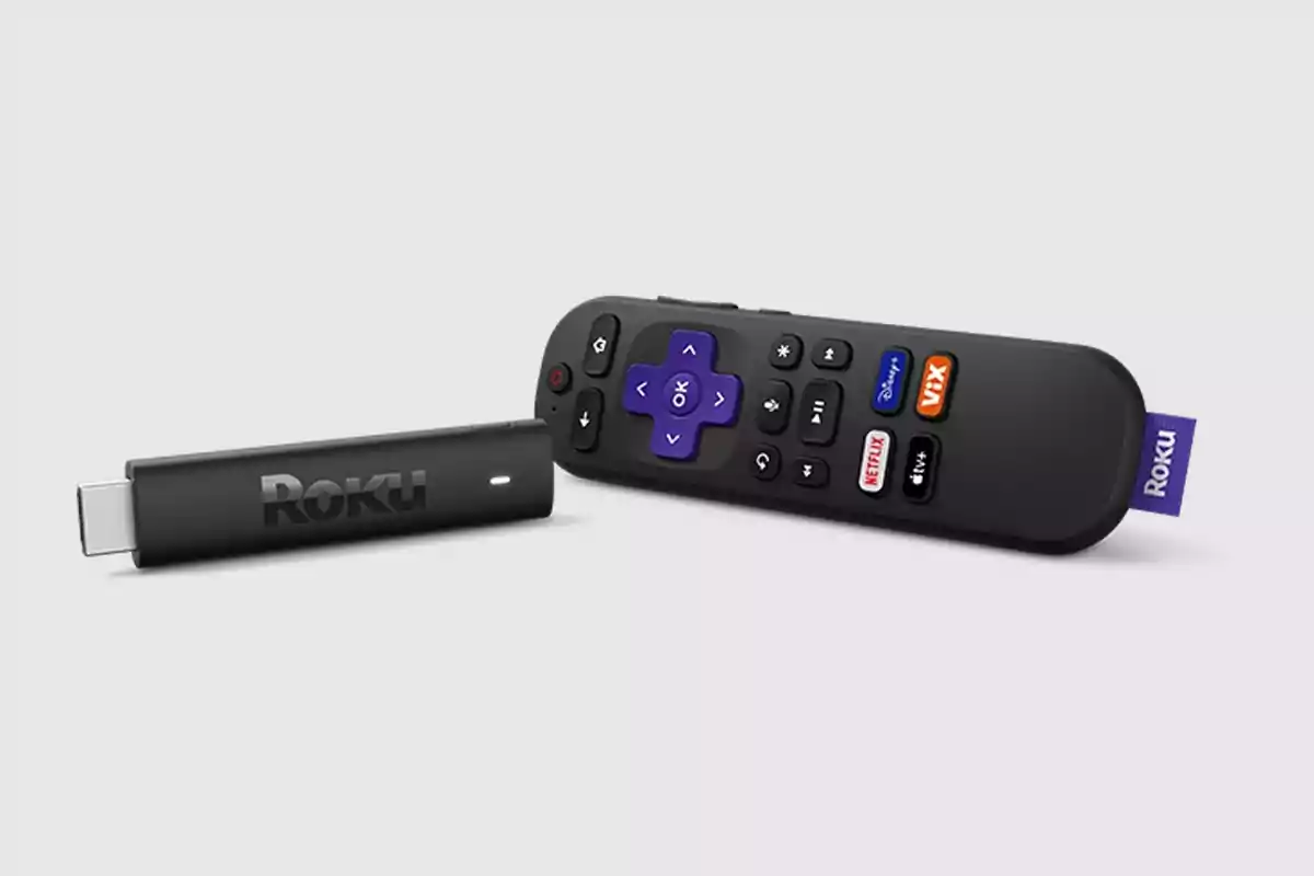 Roku remote control and streaming device on gray background Roku remote control and streaming device on gray background