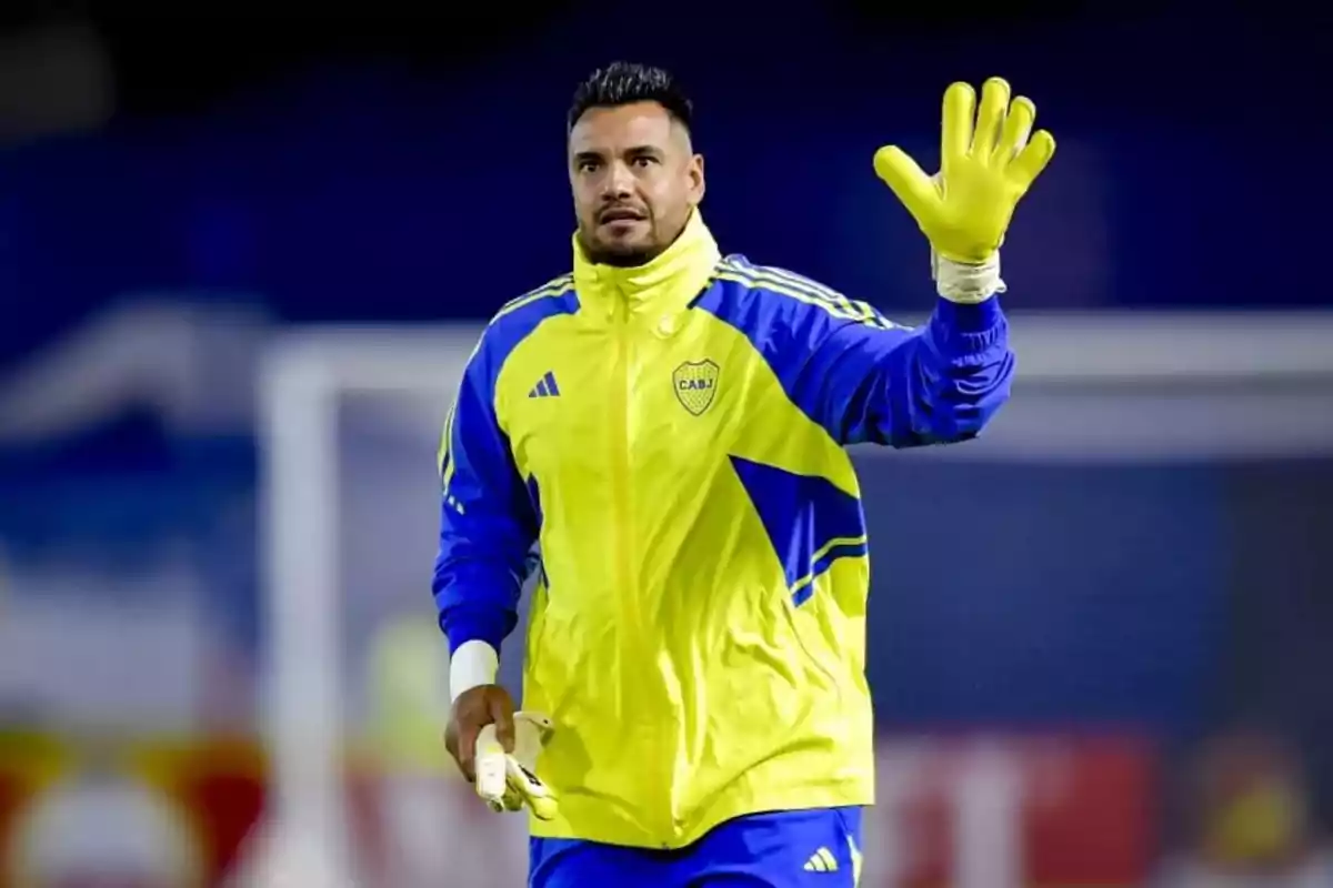 Portero de fútbol con uniforme amarillo y azul saludando con la mano enguantada en un estadio Portero de fútbol con uniforme amarillo y azul saludando con la mano enguantada en un estadio