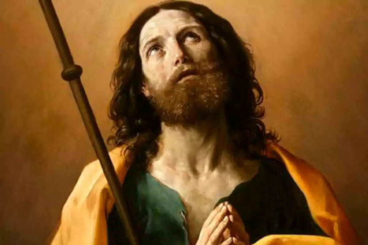 Hombre de cabello largo y barba con expresión de oración mirando hacia arriba y sosteniendo un bastón, vestido con manto amarillo y túnica verde Hombre de cabello largo y barba con expresión de oración mirando hacia arriba y sosteniendo un bastón, vestido con manto amarillo y túnica verde