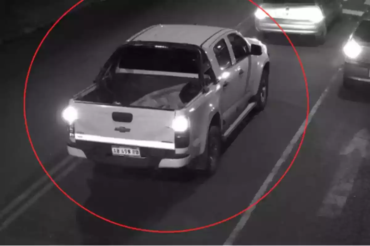 Camioneta blanca Chevrolet circulando de noche por una calle, resaltada con un círculo rojo