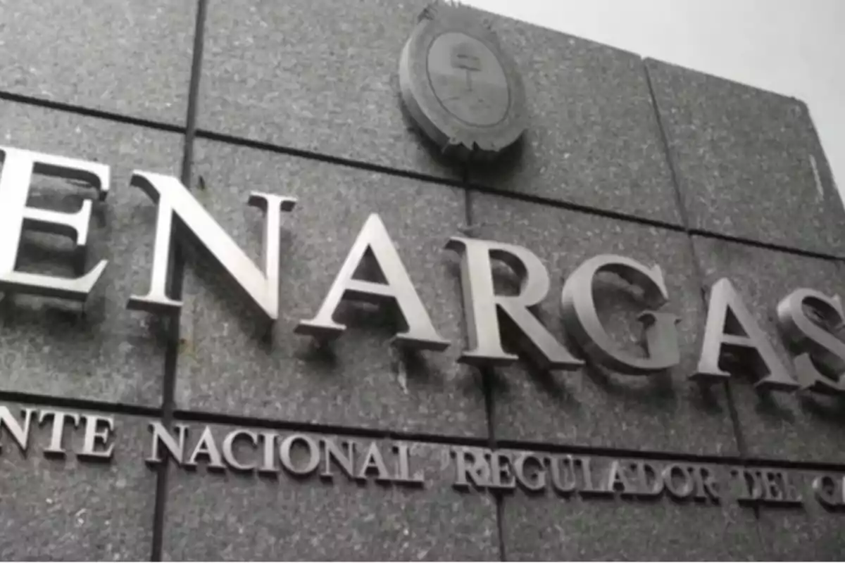 Facade of a gray granite building with the metal ENARGAS sign and the national emblem of Argentina at the top Facade of a gray granite building with the metal ENARGAS sign and the national emblem of Argentina at the top