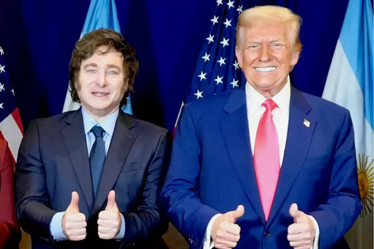 Two men in suits smile and give thumbs up in front of the flags of the United States and Argentina. Two men in suits smile and give thumbs up in front of the flags of the United States and Argentina.