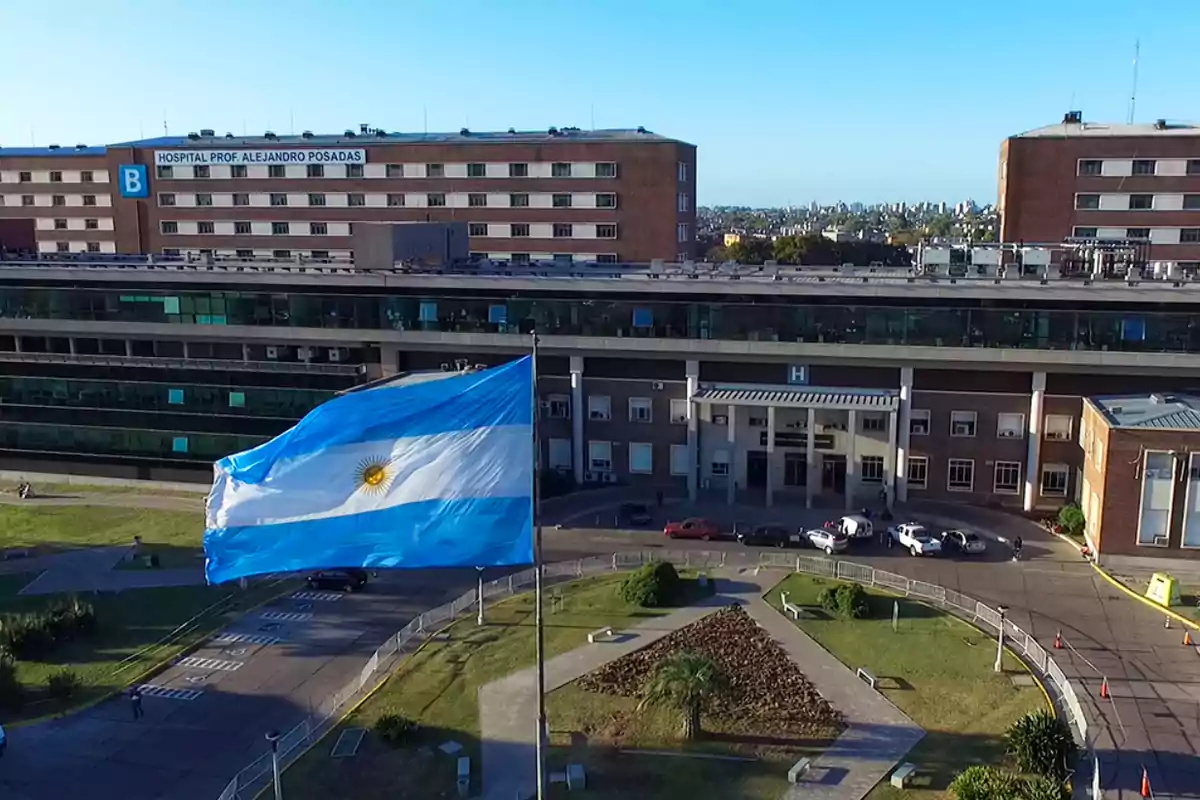 Argentine flag waving in front of the main entrance of a large hospital with brick buildings and windows Argentine flag waving in front of the main entrance of a large hospital with brick buildings and windows