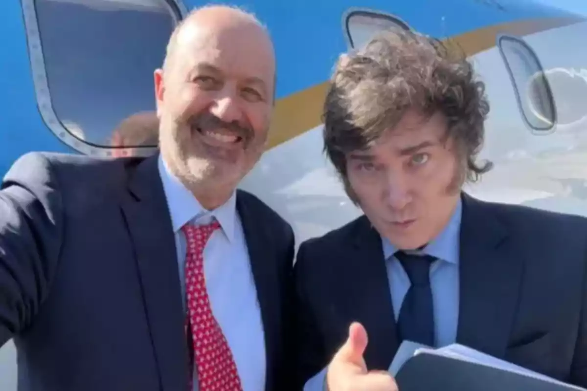 Dos hombres vestidos de traje posan sonrientes frente a un avión