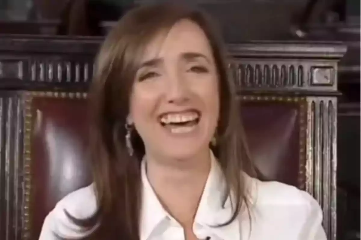 Brown-haired woman in a white jersey sitting on an elegant chair while smiling broadly Brown-haired woman in a white jersey sitting on an elegant chair while smiling broadly