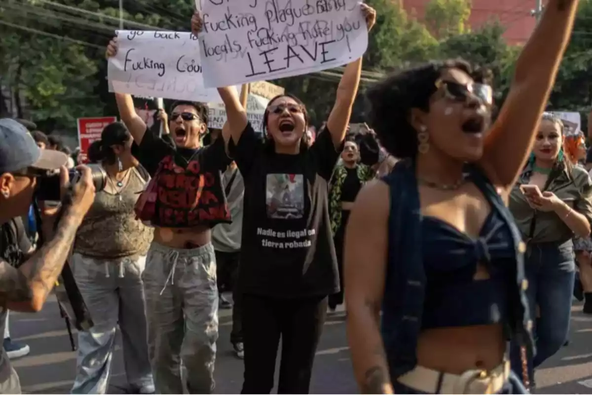 People protesting in the street with signs and expressions of dissent while a photographer captures the moment People protesting in the street with signs and expressions of dissent while a photographer captures the moment