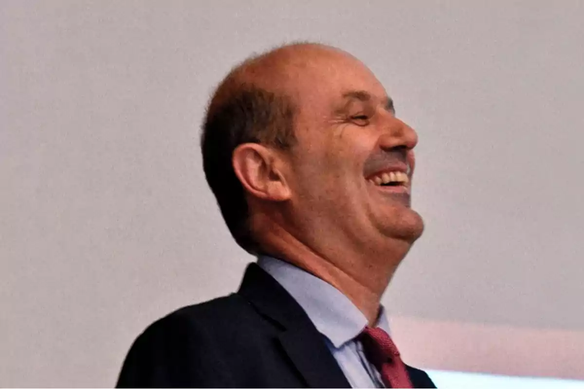 Hombre calvo de mediana edad con traje y corbata roja sonriendo ampliamente Hombre calvo de mediana edad con traje y corbata roja sonriendo ampliamente