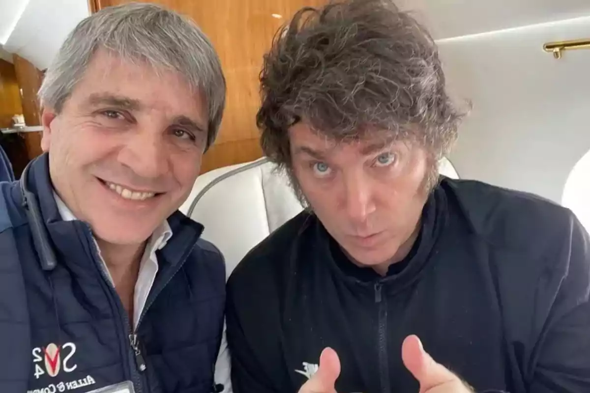 Dos hombres posan para una selfie dentro de un avión privado uno sonríe a la cámara mientras el otro hace un gesto con los pulgares hacia arriba