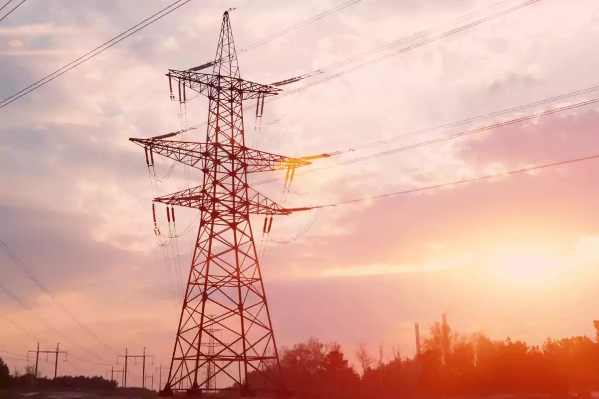 Torre de alta tensión con cables eléctricos al atardecer