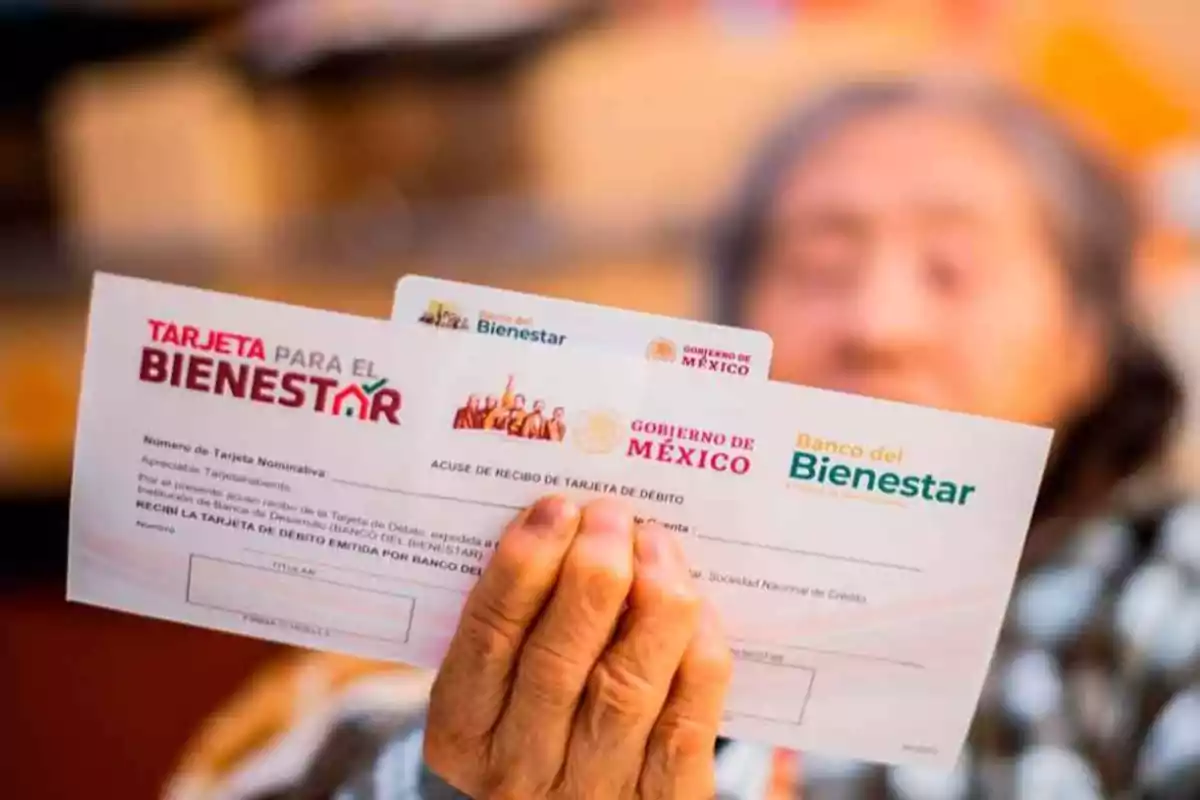 Persona mayor sostiene documentos del Banco del Bienestar y del Gobierno de México enfocados en programas sociales Persona mayor sostiene documentos del Banco del Bienestar y del Gobierno de México enfocados en programas sociales