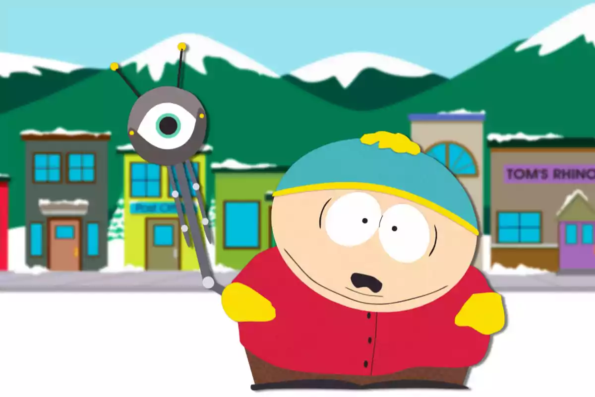 An animated character with a blue hat and yellow gloves is holding a robotic object with a large eye in a snowy village with mountains in the background.