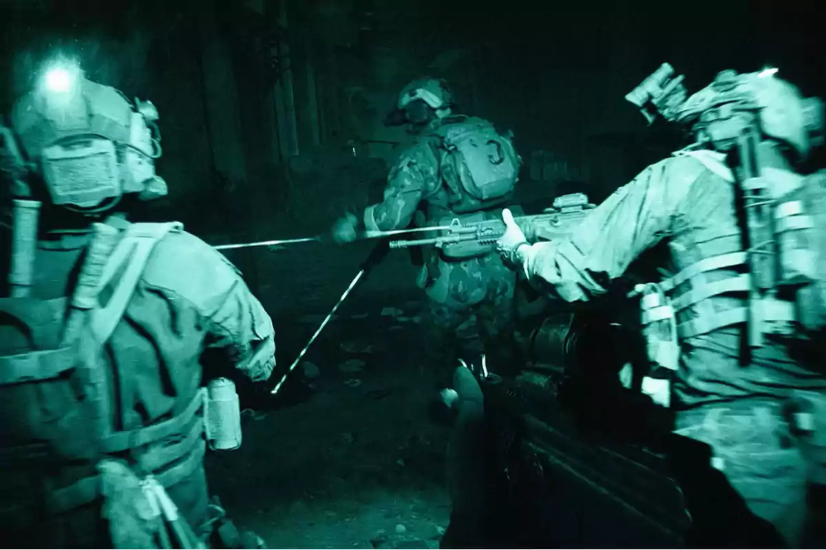 Heavily armed soldiers advance in formation into a dark building using night vision.