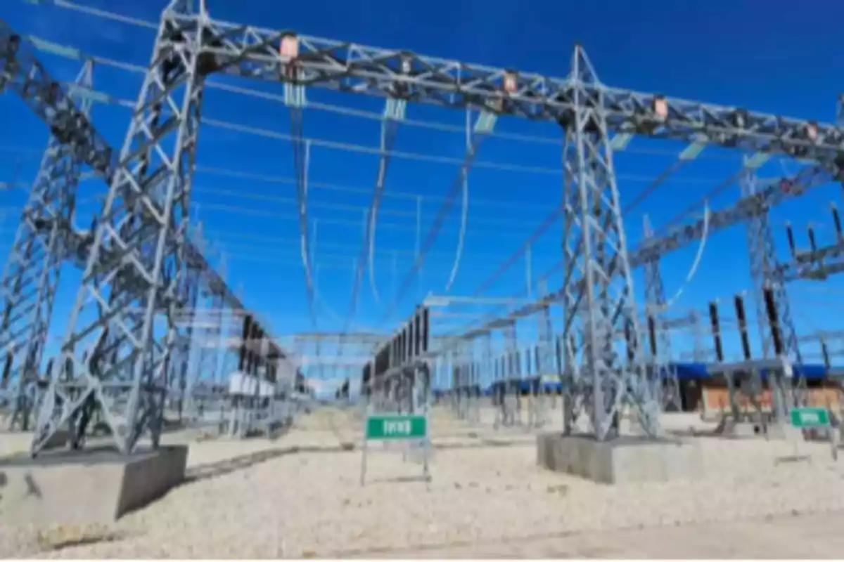 Instalación eléctrica con estructuras metálicas y cables de alta tensión bajo un cielo despejado Instalación eléctrica con estructuras metálicas y cables de alta tensión bajo un cielo despejado