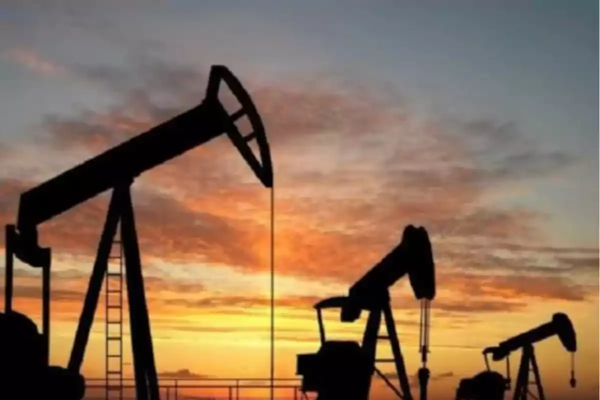 Bombas extractoras de petróleo trabajando al atardecer con el cielo anaranjado de fondo Bombas extractoras de petróleo trabajando al atardecer con el cielo anaranjado de fondo