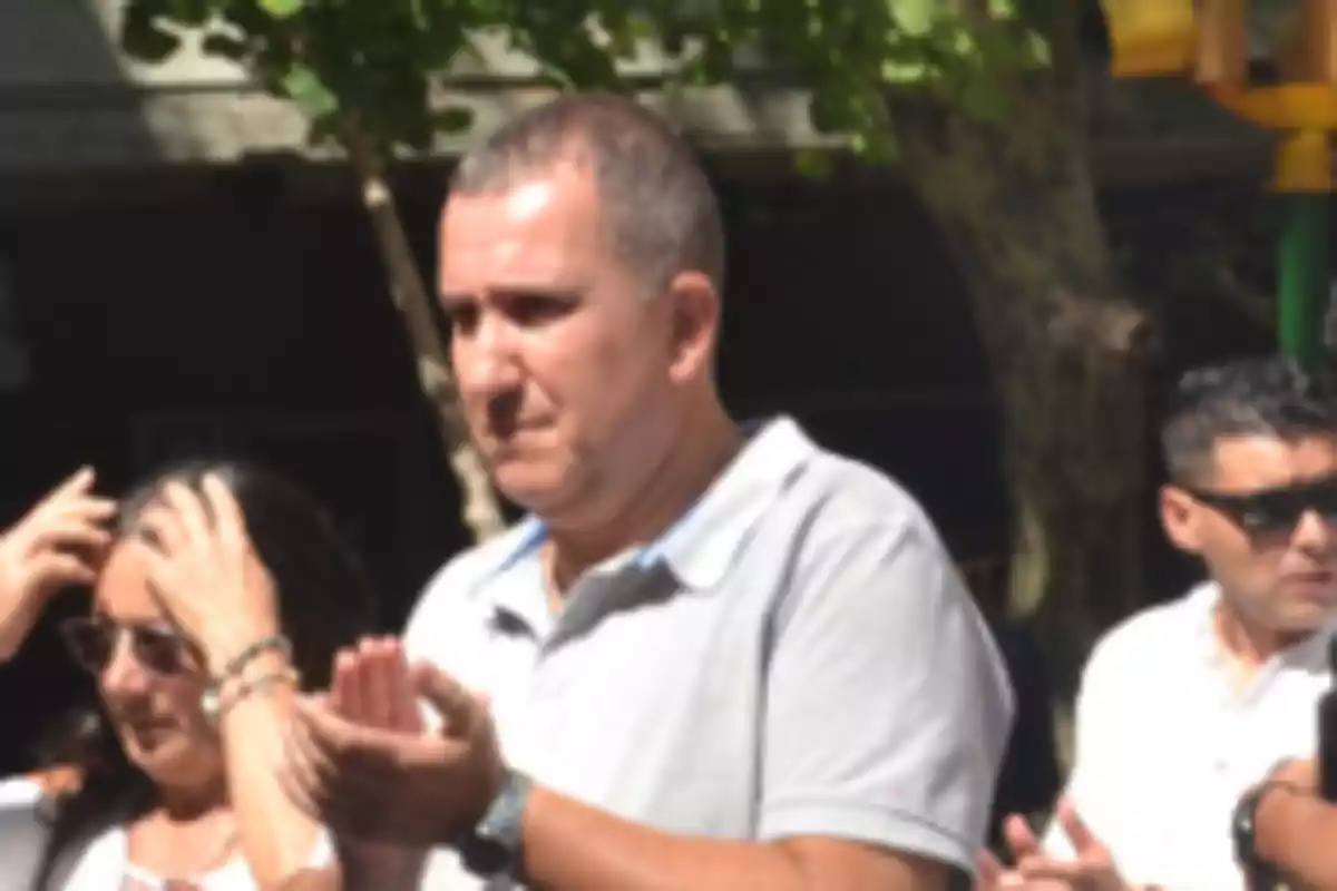 Personas desenfocadas a la intemperie aplaudiendo en un evento diurno