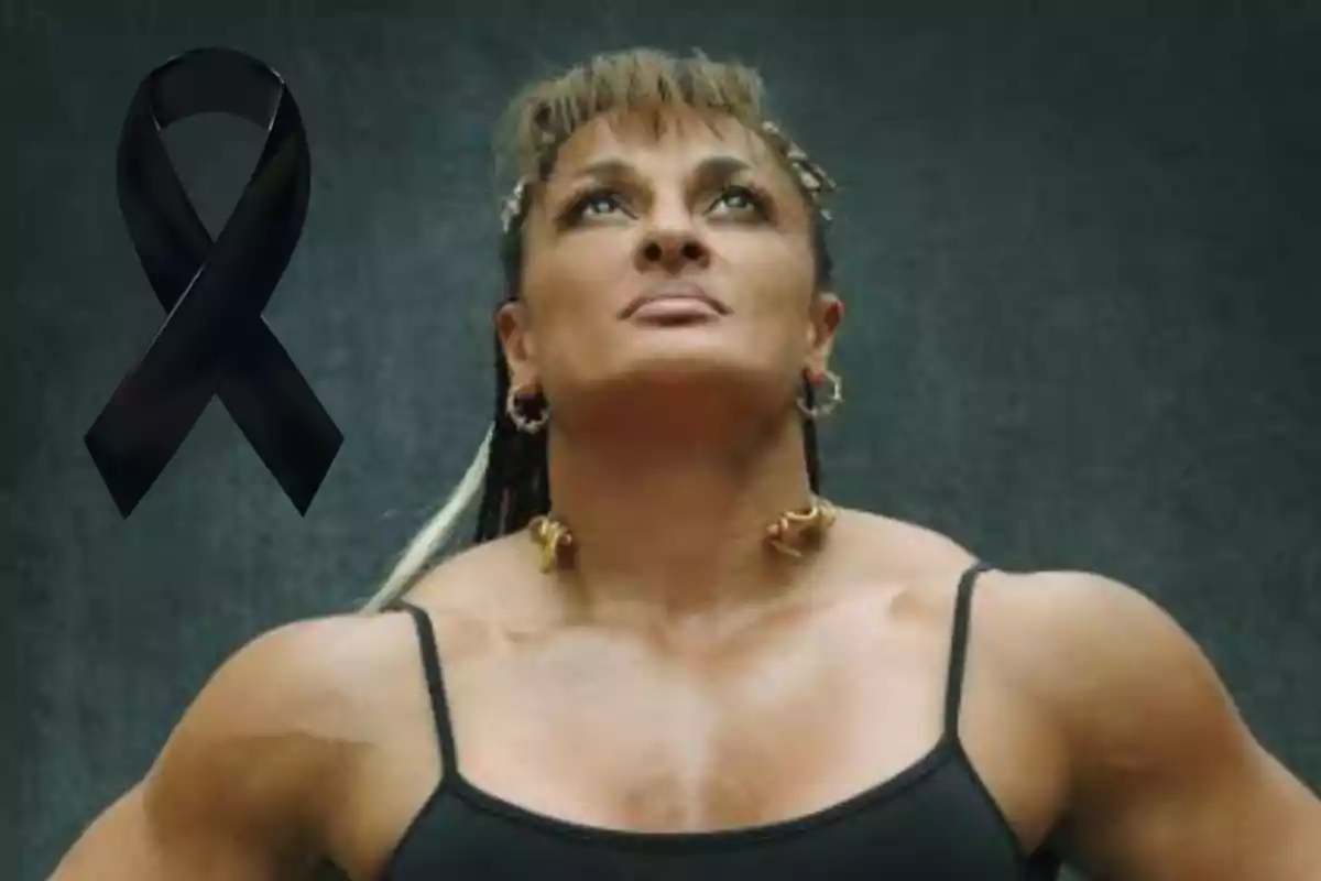 Mujer musculosa mirando hacia arriba con un listón negro de luto en la esquina izquierda