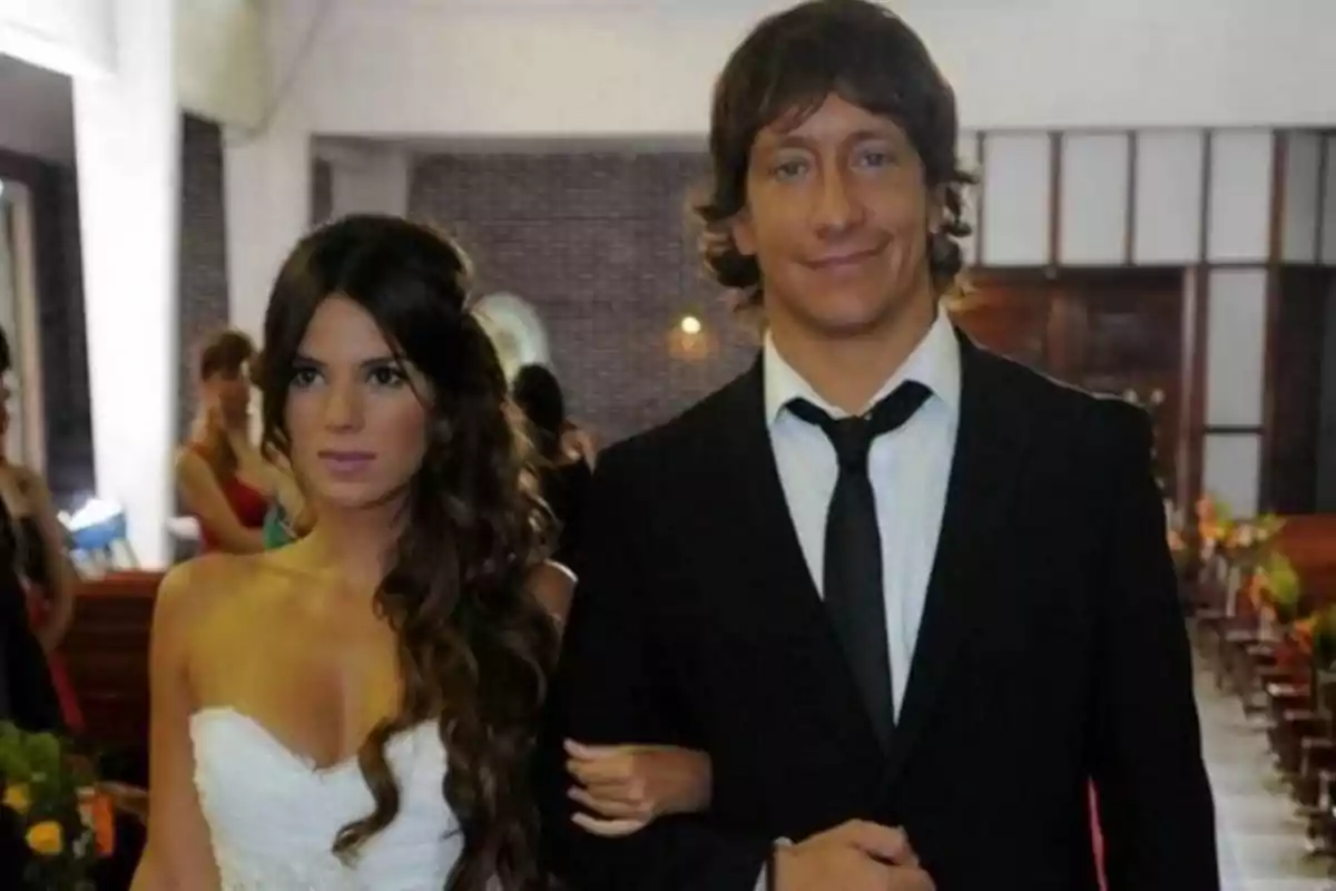 Pareja vestida de manera elegante en lo que parece ser una ceremonia de boda dentro de una iglesia Pareja vestida de manera elegante en lo que parece ser una ceremonia de boda dentro de una iglesia