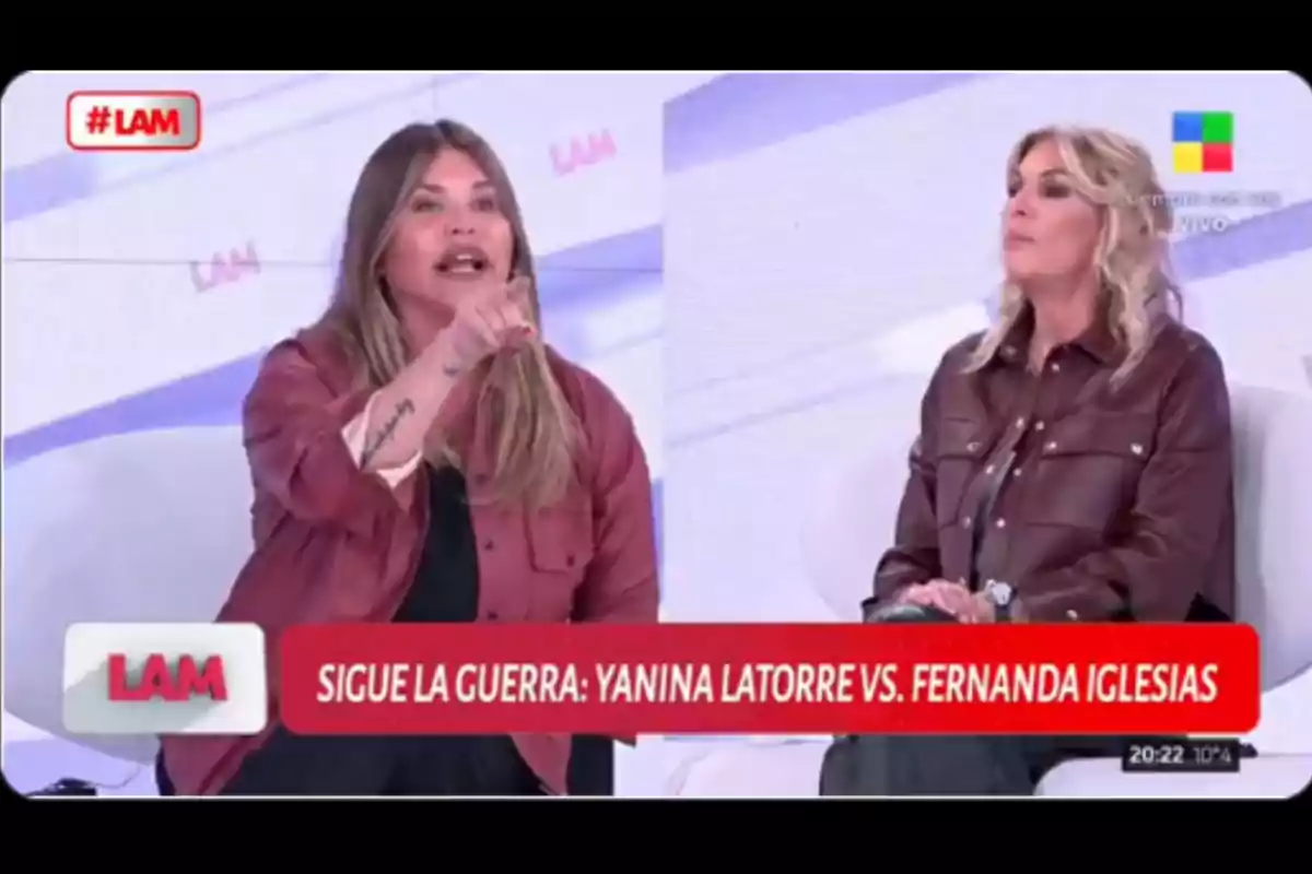 Dos mujeres discuten en un programa de televisión mientras están sentadas en un set con fondo claro y gráficos de LAM, una de ellas gesticula señalando con el dedo y la otra la observa con expresión seria. Dos mujeres discuten en un programa de televisión mientras están sentadas en un set con fondo claro y gráficos de LAM, una de ellas gesticula señalando con el dedo y la otra la observa con expresión seria.