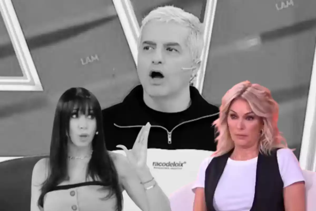Three people on a television set with surprised expressions and animated conversation