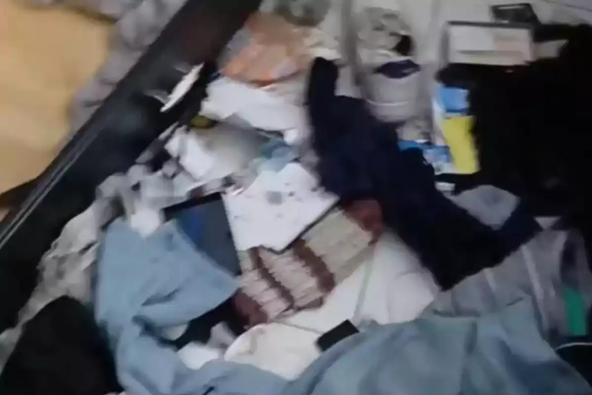 Clothes, papers, and objects scattered on the floor