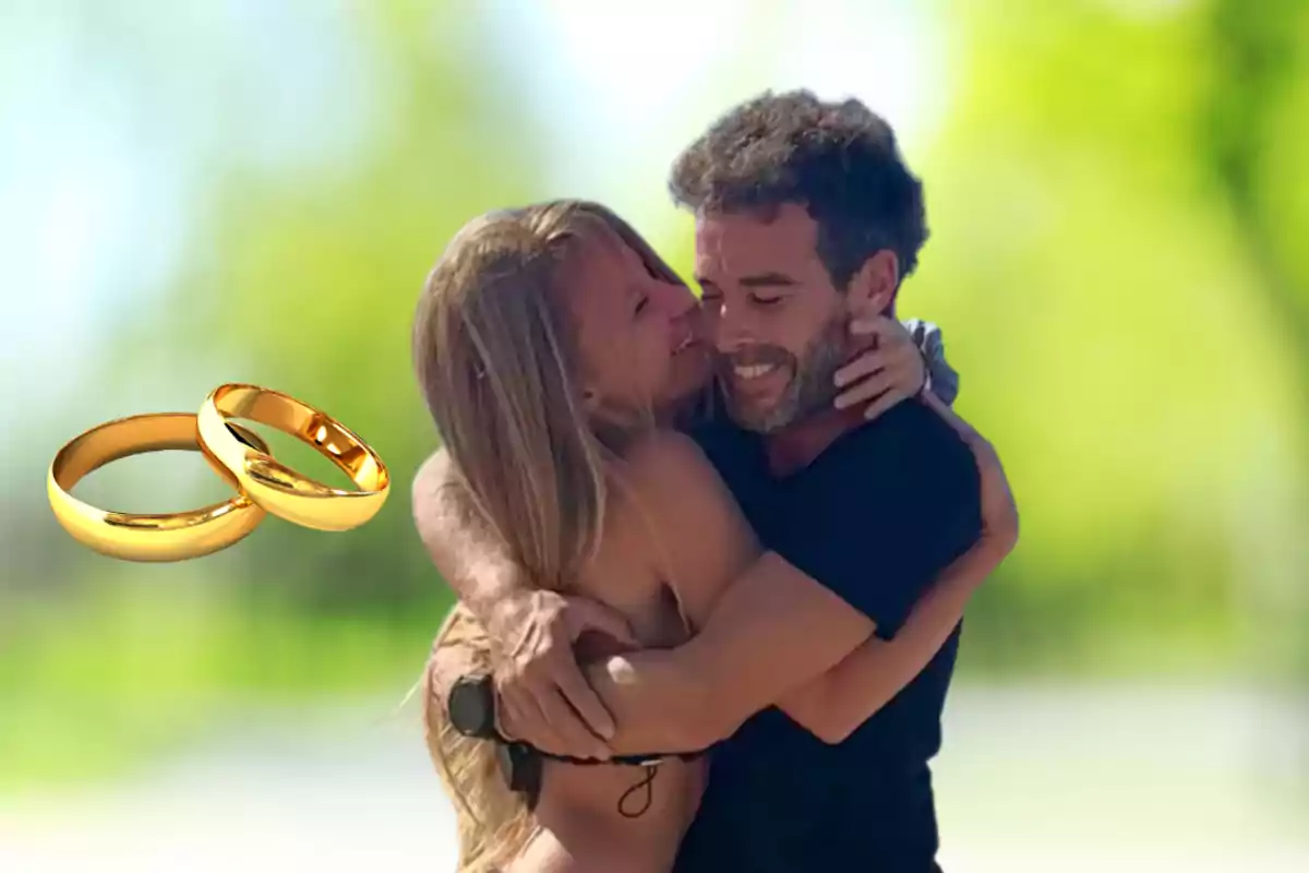 Happy couple hugging outdoors with two golden rings in the foreground