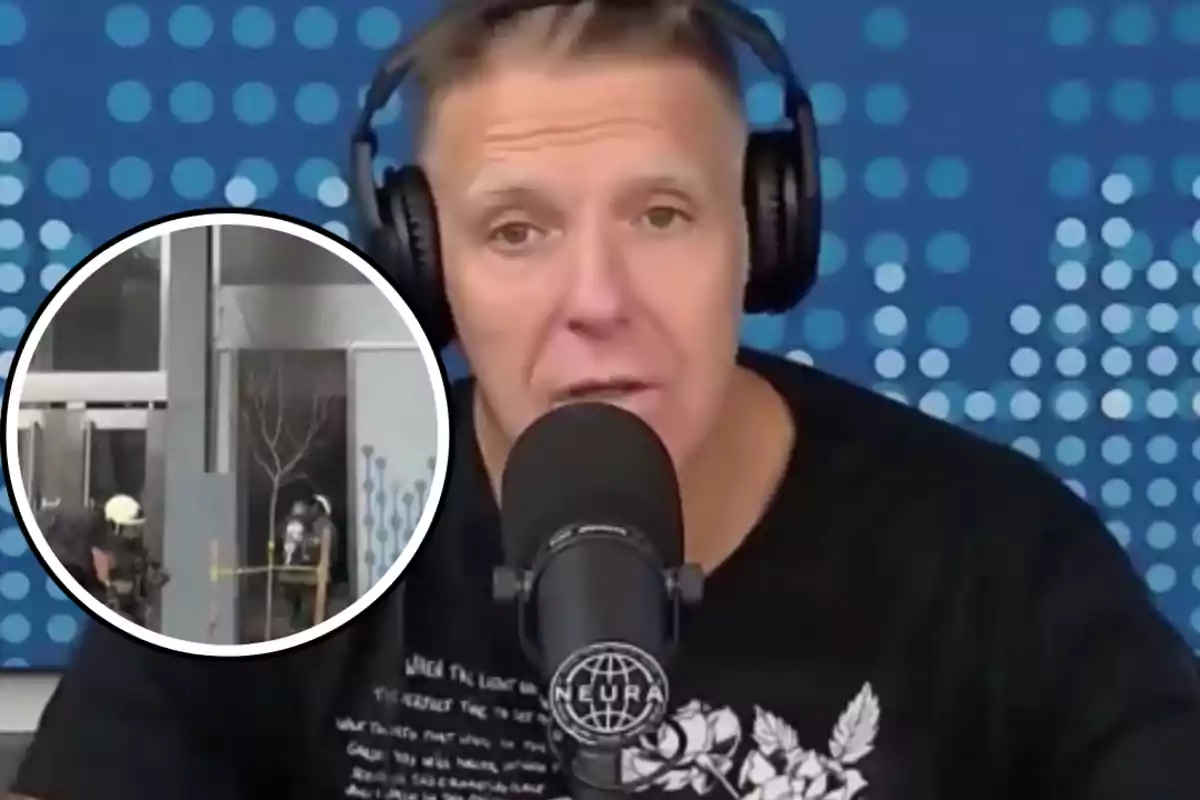 Man with headphones and microphone speaking in front of a blue wall with dots, while in one corner there is an image of firefighters working outside a building.