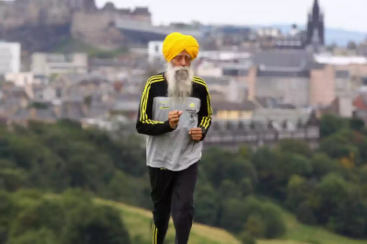 Older man with a yellow turban and long beard running outdoors with a blurred city in the background