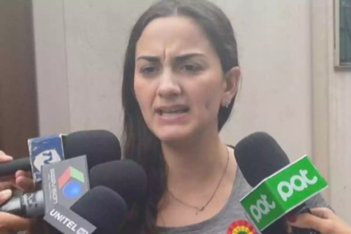 Woman speaking in front of several microphones from different media outlets Woman speaking in front of several microphones from different media outlets