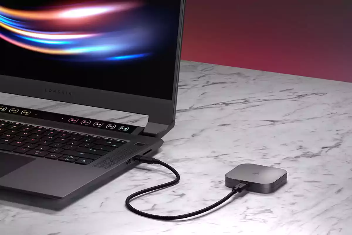 Corsair laptop on a marble table connected to a USB hub with a braided cable Corsair laptop on a marble table connected to a USB hub with a braided cable