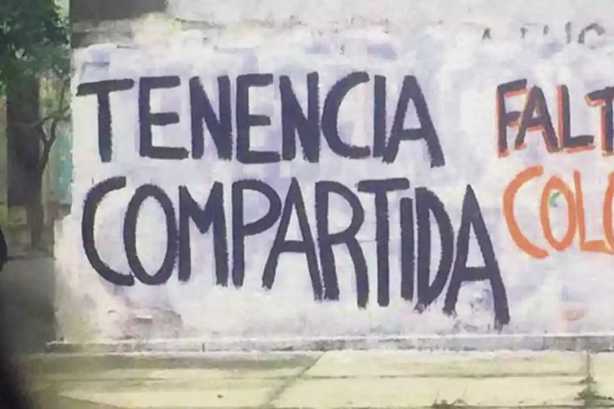 Pintada en una pared blanca con las palabras tenencia compartida escritas en letras grandes y negras Pintada en una pared blanca con las palabras tenencia compartida escritas en letras grandes y negras