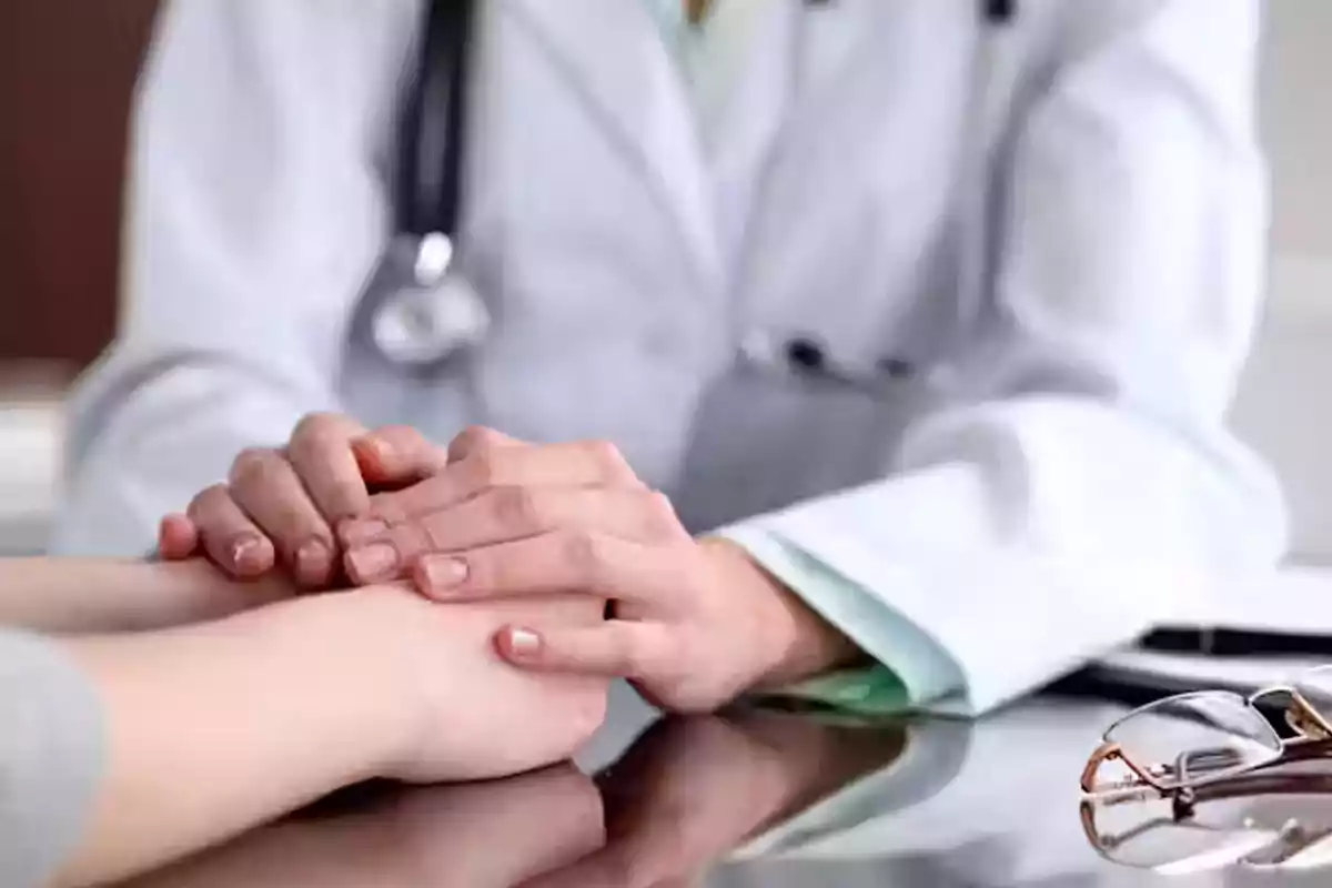 Un médico sostiene con empatía las manos de un paciente sobre una mesa durante una consulta Un médico sostiene con empatía las manos de un paciente sobre una mesa durante una consulta
