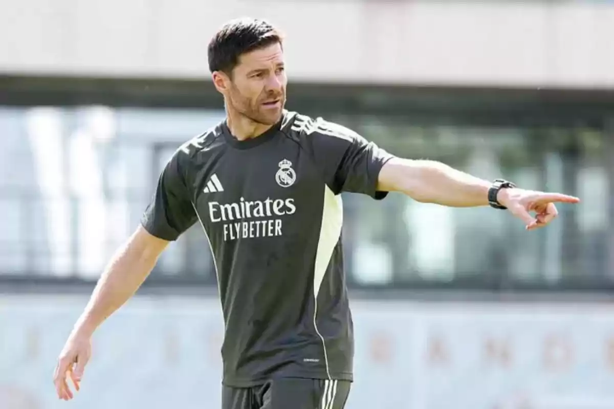 Soccer coach wearing Real Madrid training gear pointing with an outstretched arm during an outdoor practice Soccer coach wearing Real Madrid training gear pointing with an outstretched arm during an outdoor practice