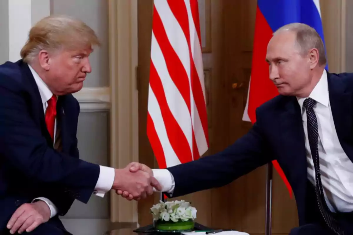 Dos hombres de traje se dan la mano frente a las banderas de Estados Unidos y Rusia Dos hombres de traje se dan la mano frente a las banderas de Estados Unidos y Rusia