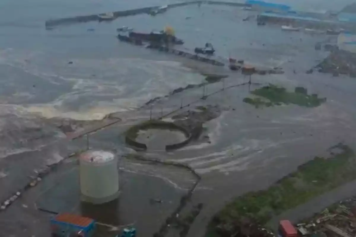 Vista aérea de un puerto inundado con agua cubriendo gran parte del área y algunos barcos cerca del muelle Vista aérea de un puerto inundado con agua cubriendo gran parte del área y algunos barcos cerca del muelle