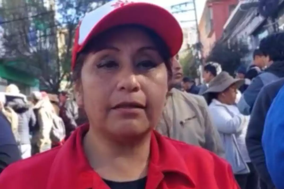 Mujer con gorra y chaqueta roja en una manifestación rodeada de personas en la calle Mujer con gorra y chaqueta roja en una manifestación rodeada de personas en la calle