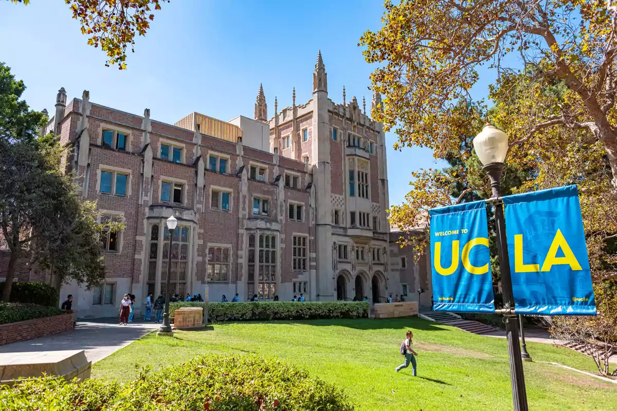 Brick university building with large windows and a blue and yellow UCLA sign on a sunny day Brick university building with large windows and a blue and yellow UCLA sign on a sunny day